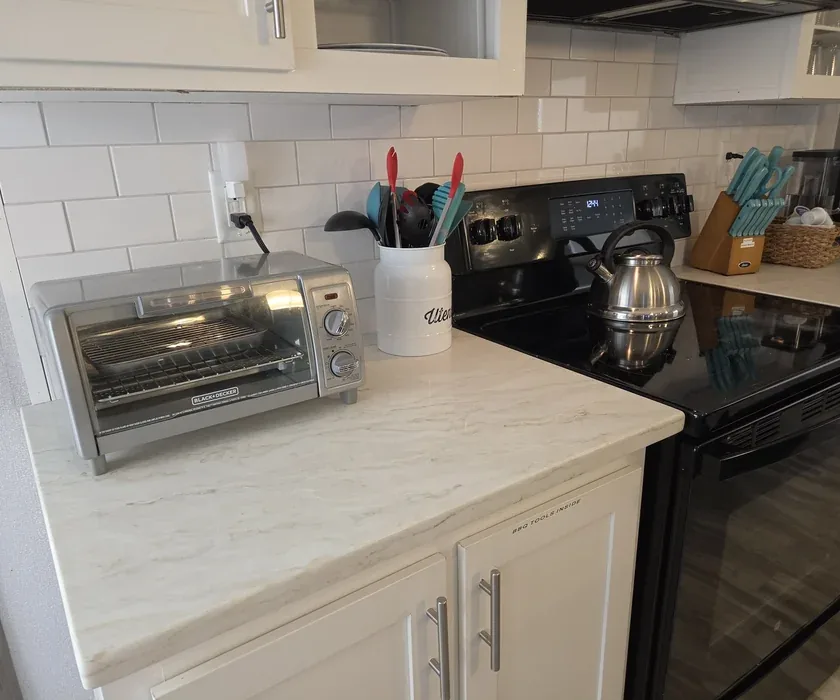 Stone countertop edge and tile backsplash detail in a remodeled kitchen