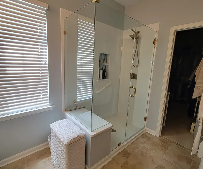 Ceramic shower tile and custom glass enclosure detail from a bathroom renovation