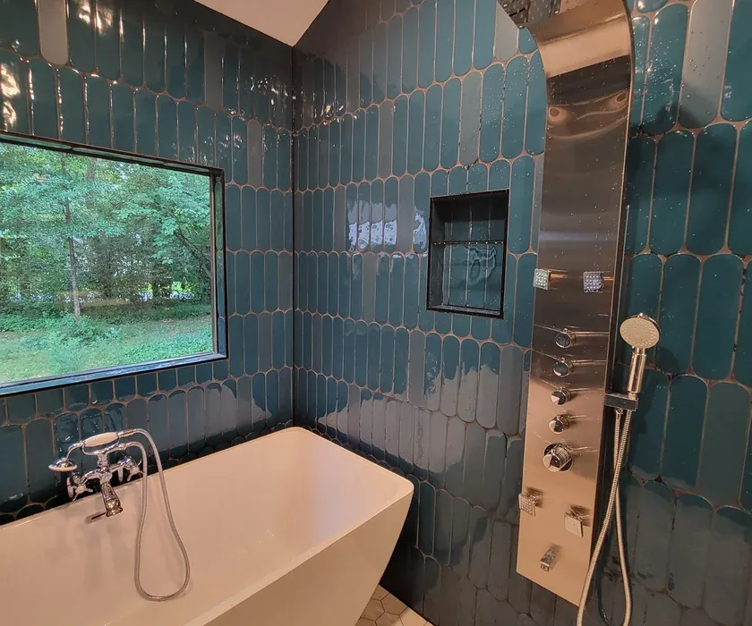 Ceramic shower tile and custom glass enclosure detail from a bathroom renovation