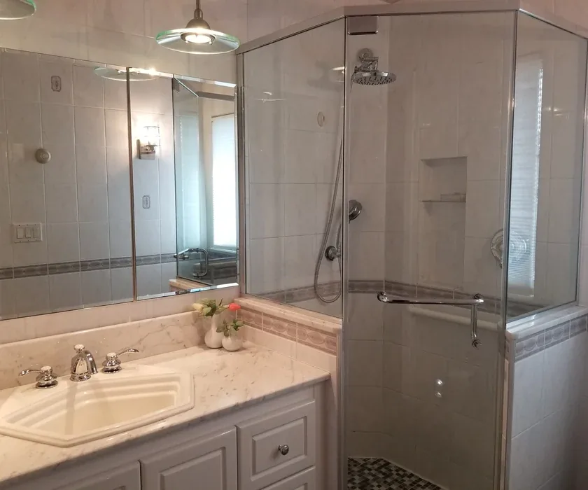 Ceramic shower tile and custom glass enclosure detail from a bathroom renovation